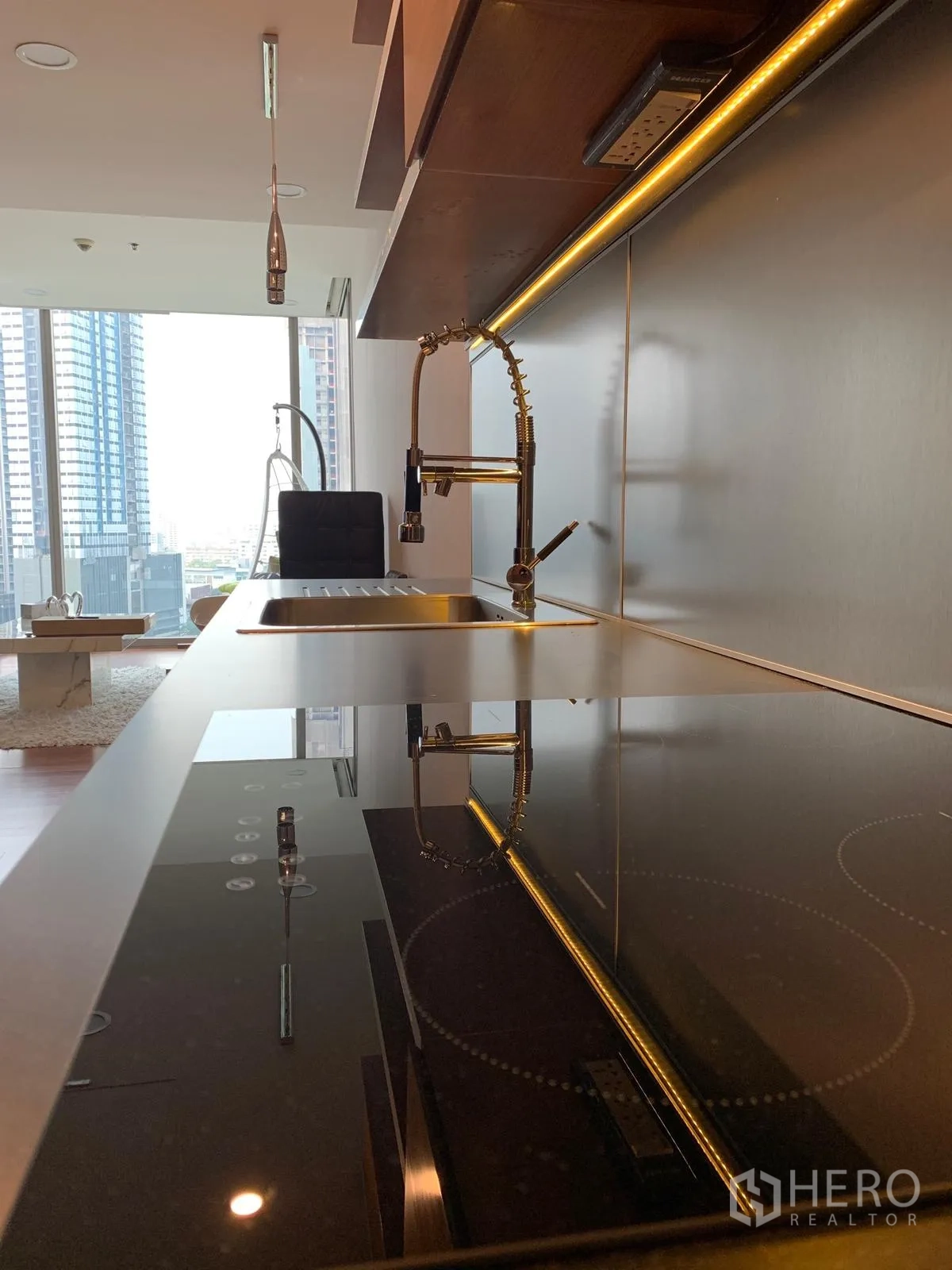 公寓 出售在Khlong Toei, Bangkok - 光滑台面，电磁炉与弹簧龙头，面向城市景观。