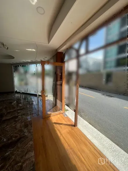 Retail Space for rent in Watthana, Bangkok - Glass shopfront entrance with wooden door and floor-to-ceiling windows opening to the street.