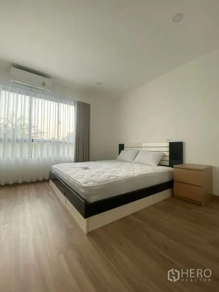 Townhouse for rent in Bang Kapi, Bangkok - Bright master bedroom with queen bed, wood floor, sheer curtains and AC in a Bang Kapi townhouse.