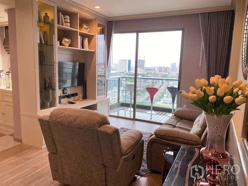 Condominium for sale in Bang Kho Laem, Bangkok - Cozy living room with sofa, media shelving and balcony city view.