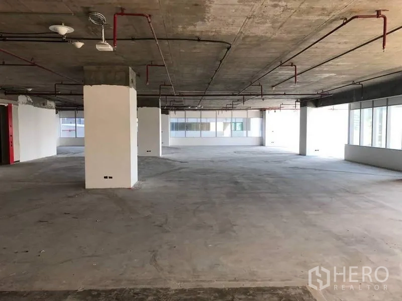 Office Space for rent in Bang Na, Bangkok - Open-plan office with exposed concrete ceiling, sprinkler pipes, and columns.