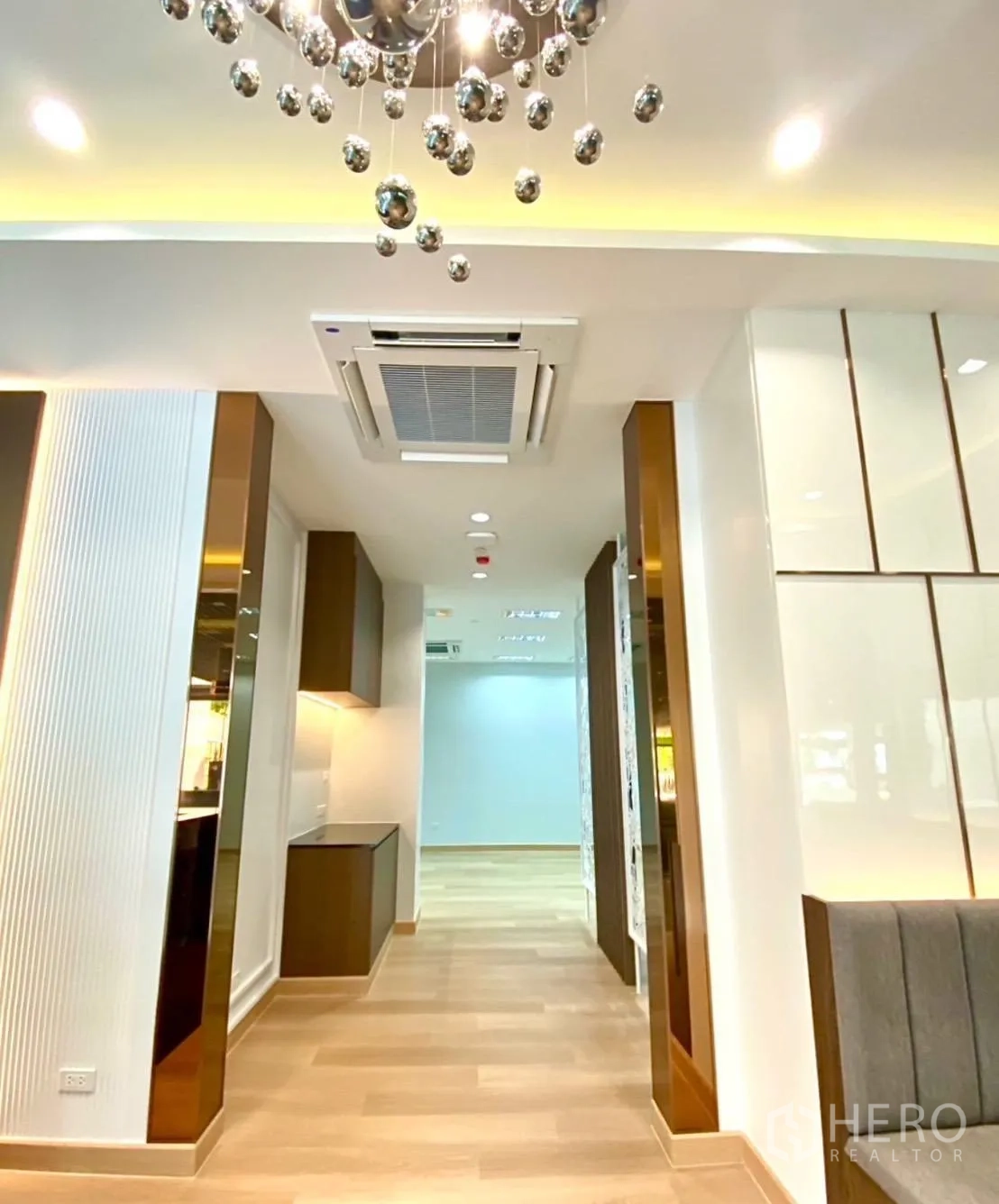 Office Space for rent - Close-up of decorative chandelier and hallway with recessed lighting and AC.