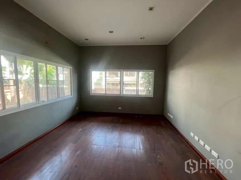 独立式住宅 出租在Watthana, Bangkok - 采光充足的房间，长条窗望向绿植，木地板。