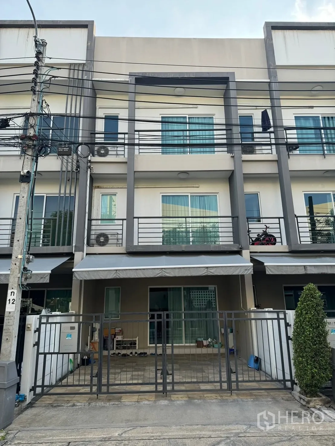 联排别墅 for rent in Suan Luang, Bangkok - 三层现代联排外立面，设阳台与栅栏车位。