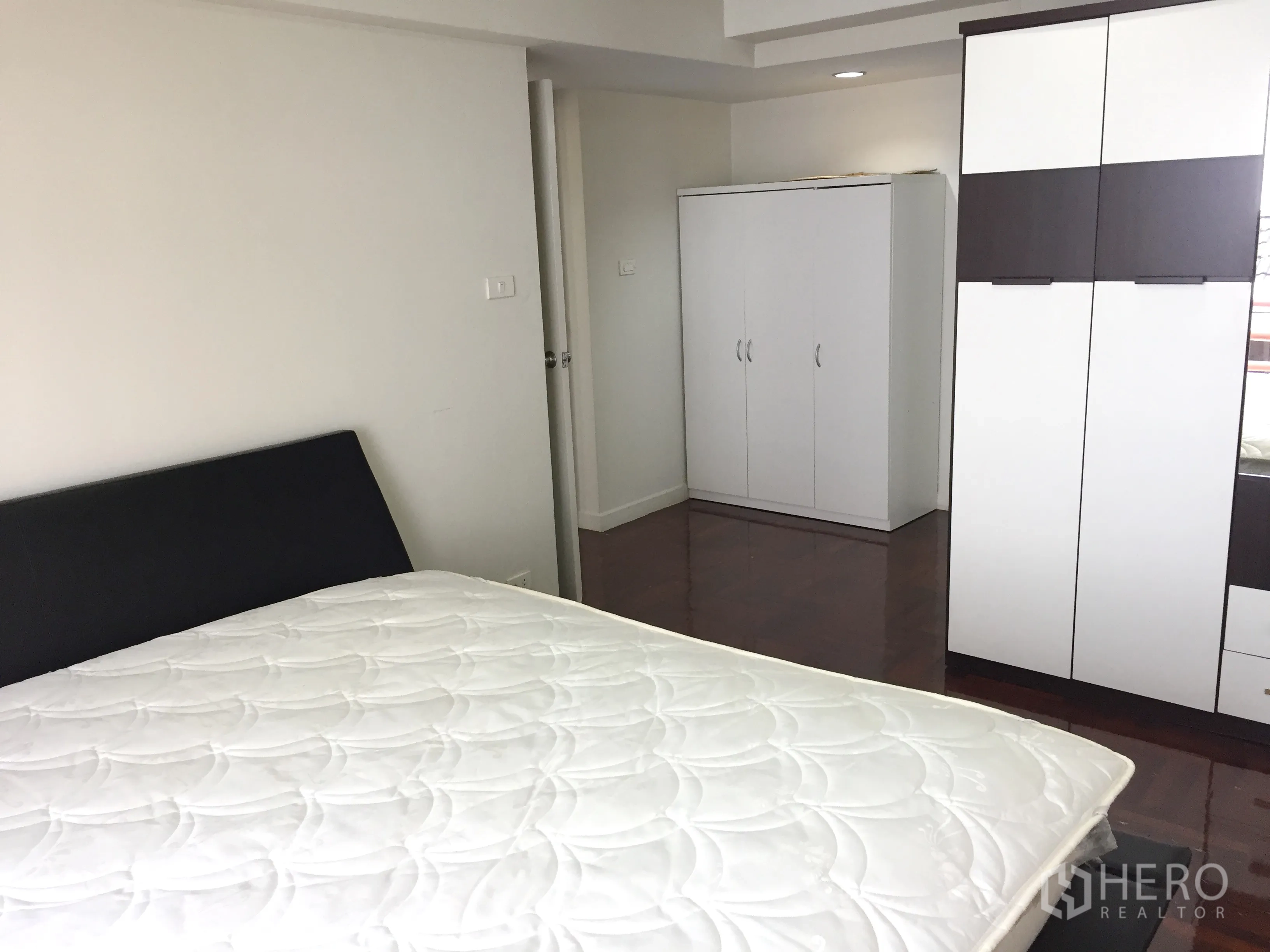 Detached House for rent in Watthana, Bangkok - Bright guest bedroom with wardrobes and glossy wood floor.