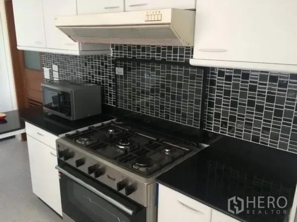 คอนโด ให้เช่าในKhlong Toei, Bangkok - ห้องครัวบิลท์อิน เตาแก๊ส เตาอบ เครื่องดูดควัน ท็อปหินแกรนิตสีดำ และผนังกระเบื้องโมเสก