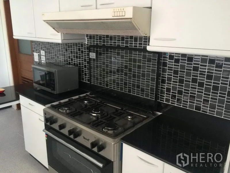 คอนโด ให้เช่าในKhlong Toei, Bangkok - ห้องครัวบิลท์อิน เตาแก๊ส เตาอบ เครื่องดูดควัน ท็อปหินแกรนิตสีดำ และผนังกระเบื้องโมเสก