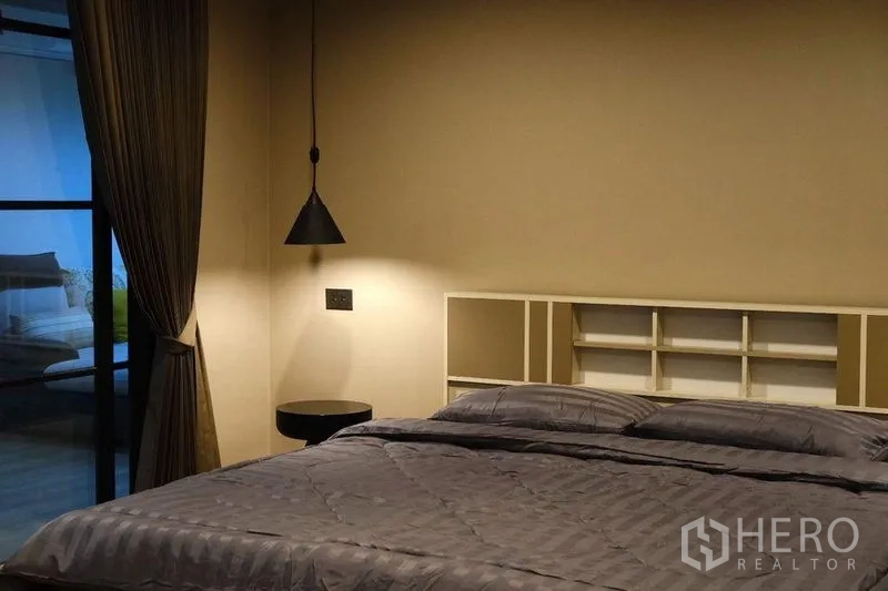 公寓 出租在Bang Rak, Bangkok - 温馨卧室，吊灯、内置搁架与大床。