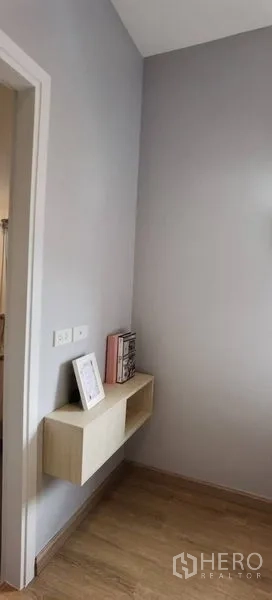 联排别墅 出租在Prawet, Bangkok - 小走廊配悬空置物架，浅灰墙面与木地板。