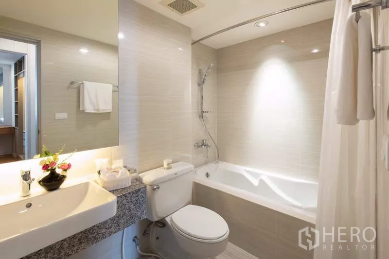 Apartment for rent - Contemporary bathroom with bathtub and shower combo, wide vanity, toilet and neutral tiles.