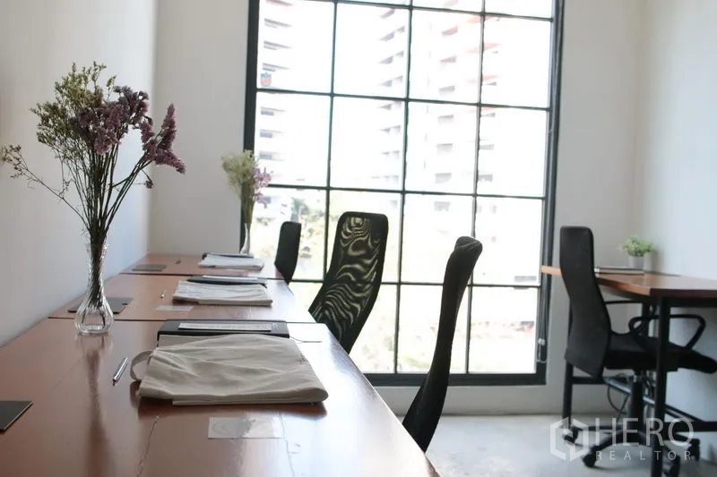สำนักงาน ให้เช่าในKhlong Toei, Bangkok - โต๊ะทำงานเรียงชิดหน้าต่างกระจกกรอบดำแบบลอฟต์ รับแสงธรรมชาติ เห็นวิวเมือง ภายในออฟฟิศย่านทองหล่อ
