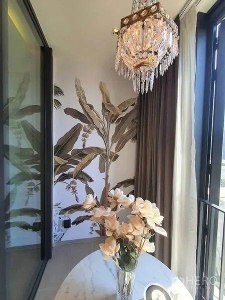 คอนโด ให้เช่าในKhlong Toei, Bangkok - ซันรูมสว่างไสว โคมไฟคริสตัล ผนังลายทรอปิคัล และแจกันบนโต๊ะกลม