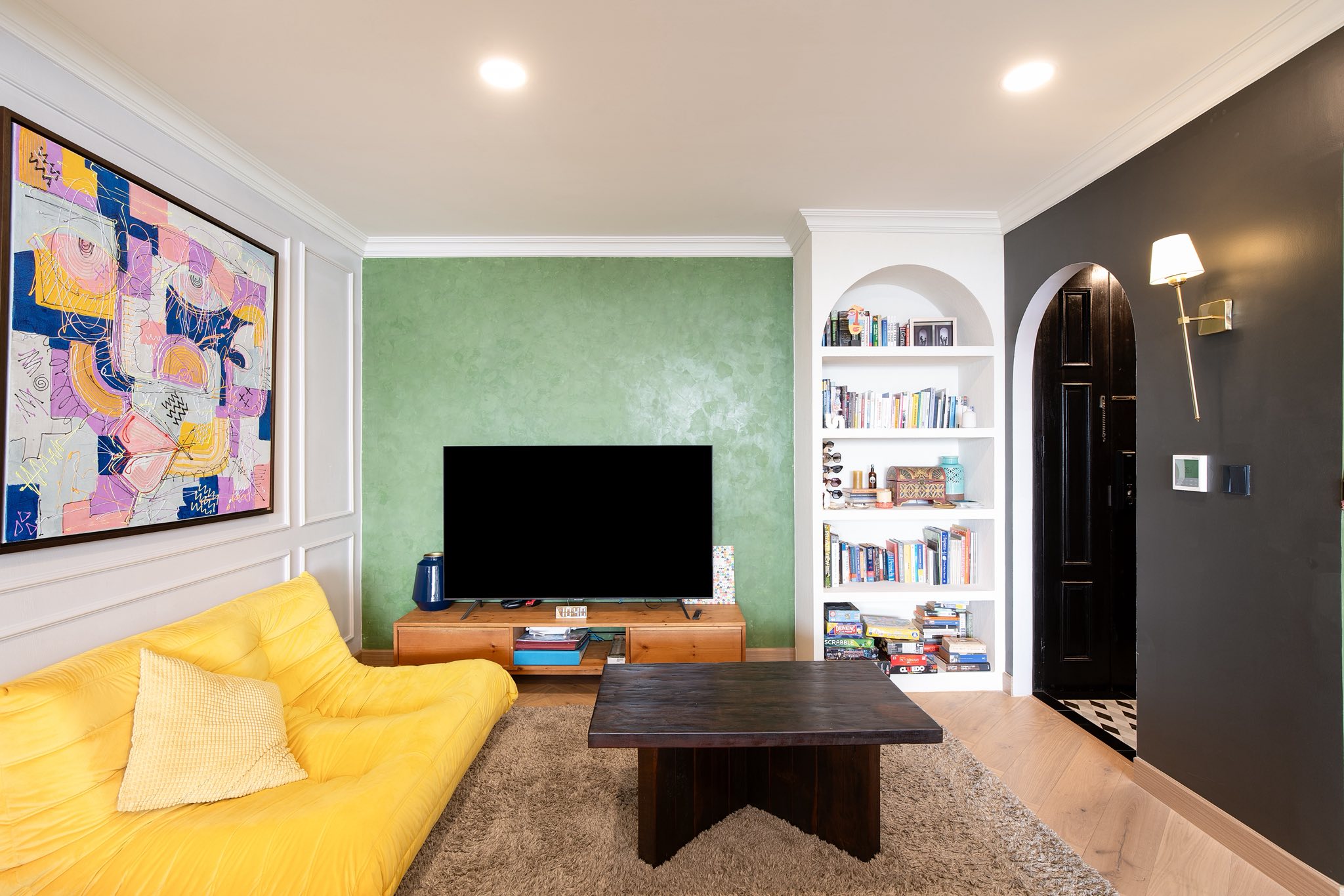 คอนโด ให้เช่าในWatthana, Bangkok - ห้องนั่งเล่น โซฟาสีเหลือง ทีวี ชั้นวางบิลท์อิน และผนังเขียวเท็กซ์เจอร์