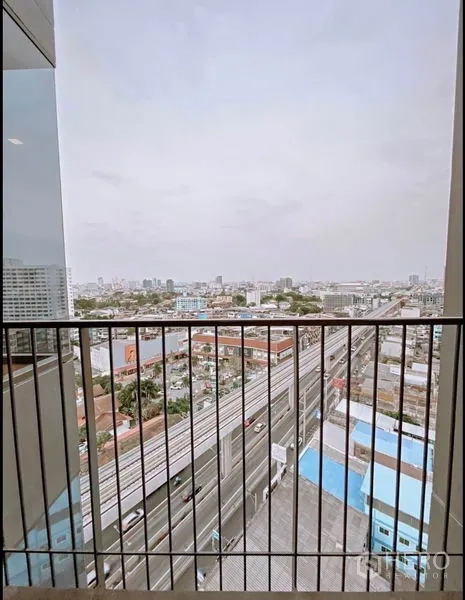 Condominium for sale in Chatuchak, Bangkok - Balcony with railings overlooking Bangkok skyline and elevated rail line.