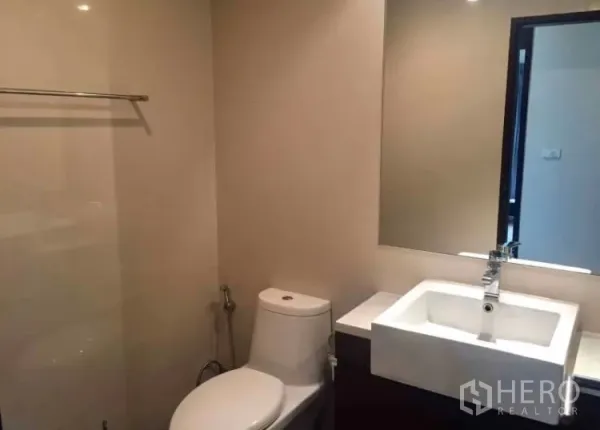 คอนโด ให้เช่าในKhlong Toei, Bangkok - ห้องน้ำสมัยใหม่พร้อมอ่างล้างหน้าเหลี่ยม กระจกบานใหญ่ และโถสุขภัณฑ์