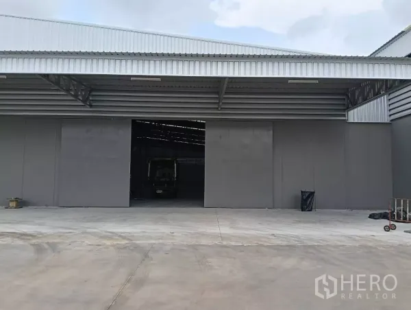 Warehouse for rent in Samut Prakan - Open loading bay with wide doors and a truck inside the warehouse on a spacious apron.