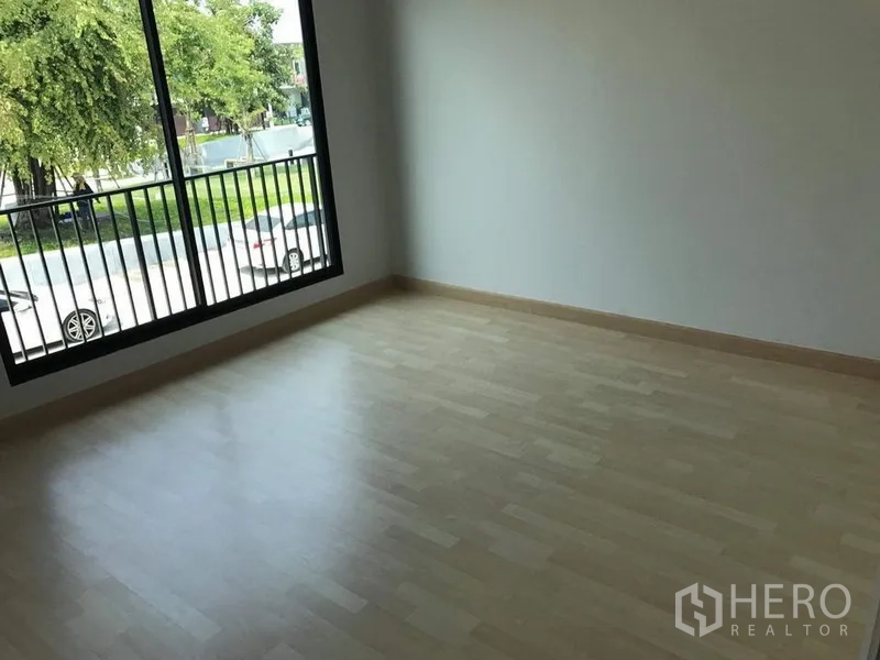 Townhouse for rent - Upstairs bedroom with light laminate floor and large window overlooking the street and trees.