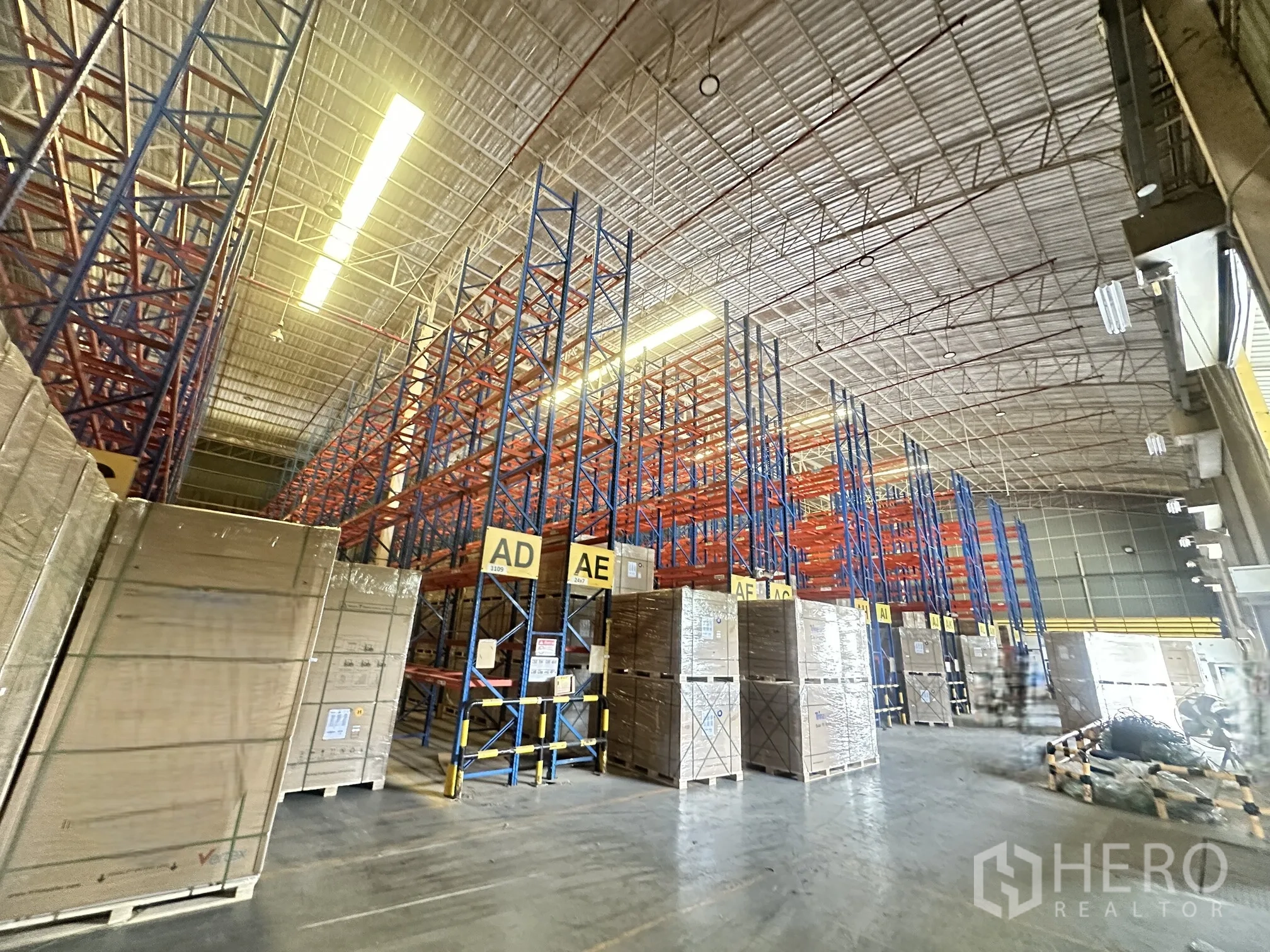 Warehouse for rent in Lat Krabang, Bangkok - Wide warehouse aisle with high racking systems and palletized goods.
