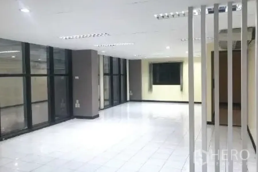 办公空间 出租在Bang Rak, Bangkok - 通透开放办公区，落地窗、白色地砖与竖向装饰隔断。