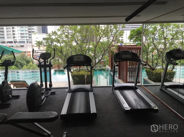 คอนโด ให้เช่าในWatthana, Bangkok - ฟิตเนสคอนโดมีลู่วิ่ง มองออกไปเห็นสระว่ายน้ำและสวน