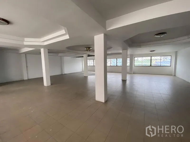 Warehouse for rent in Bang Phli, Samut Prakan - Large tiled office or multipurpose room with wide windows inside the warehouse complex.