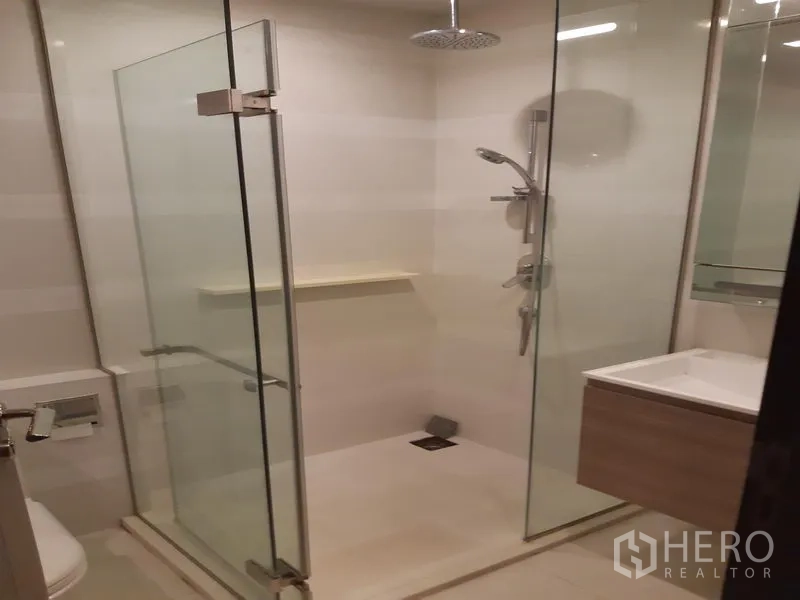 公寓 出租在Khlong Toei, Bangkok - 现代卫浴，玻璃干湿分离的雨淋花洒、洗手台与坐便器。