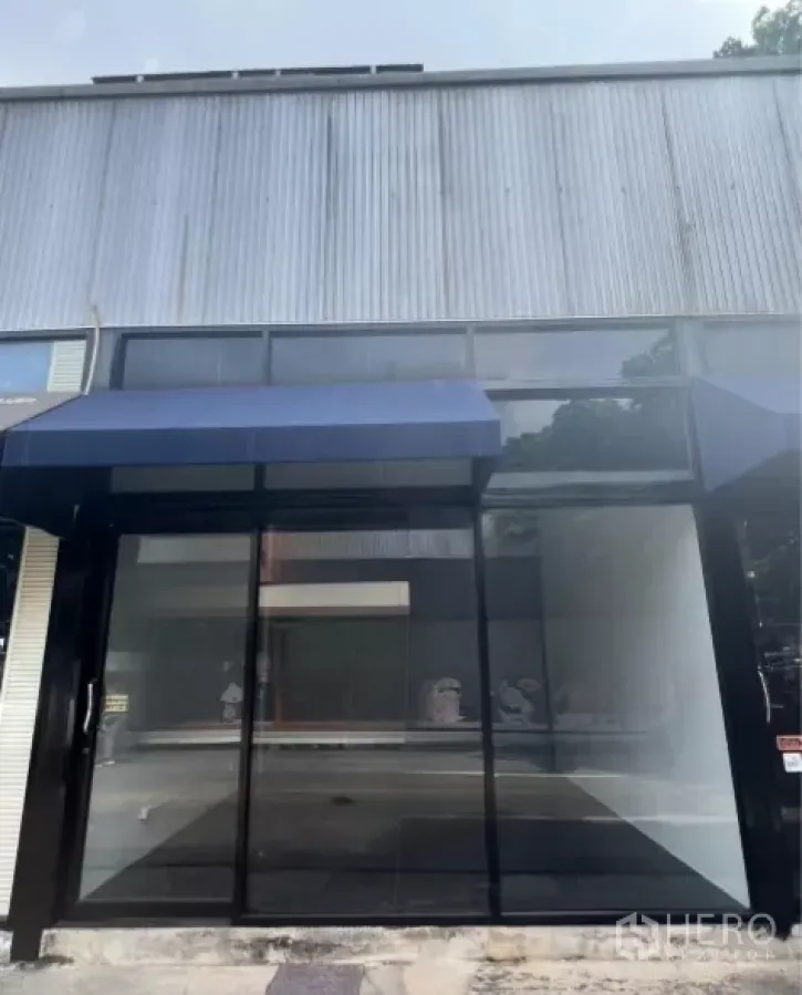 Retail Space for rent in Khlong Toei, Bangkok - Street-level retail unit with full-height glass storefront and blue awning in Khlong Toei, Bangkok.