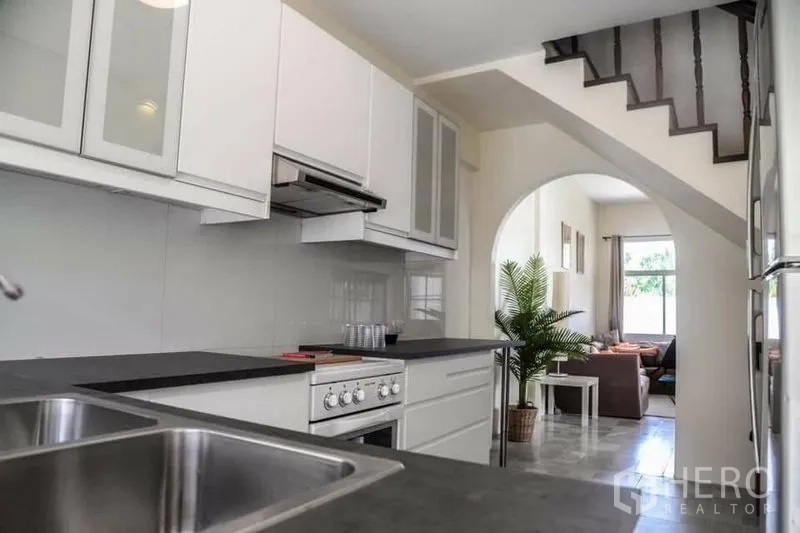 สำนักงานที่บ้าน ให้เช่าในMin Buri, Bangkok - ครัวบิวท์อินสีขาว เคาน์เตอร์หิน ซิงก์คู่และเตาอบ ใกล้บันได