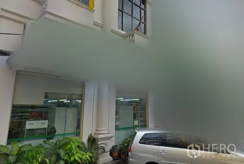 พื้นที่ขายปลีก ให้เช่าในBang Rak, Bangkok - หน้าร้านชั้นล่างสไตล์คลาสสิก เสากลม กระจกบานใหญ่ มีต้นไม้กระถางและที่จอดรถใกล้เคียง ในเขตบางรัก กรุงเทพฯ