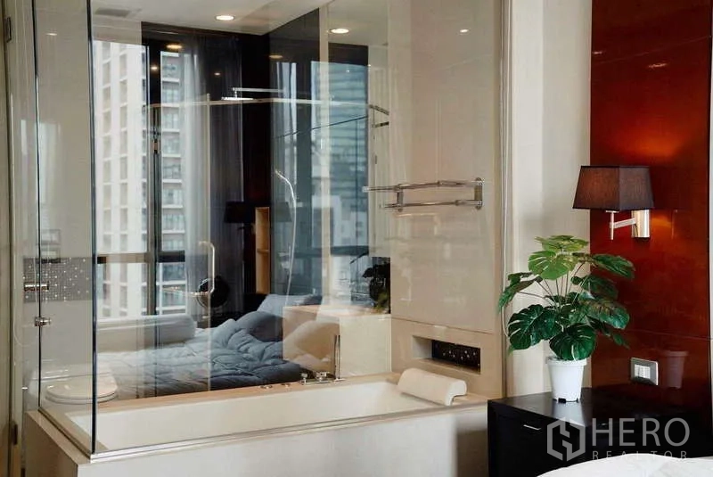 公寓 出租或出售 - 浴缸与淋浴间玻璃隔断，远处卧室与城市景。