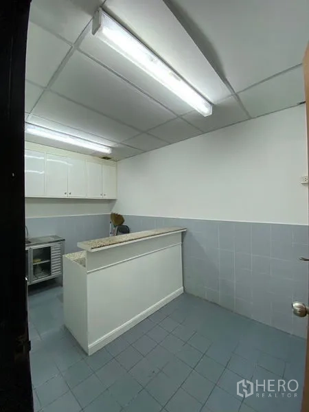 办公空间 出租 - 员工茶水间，带操作台、储物柜与灰色地砖。