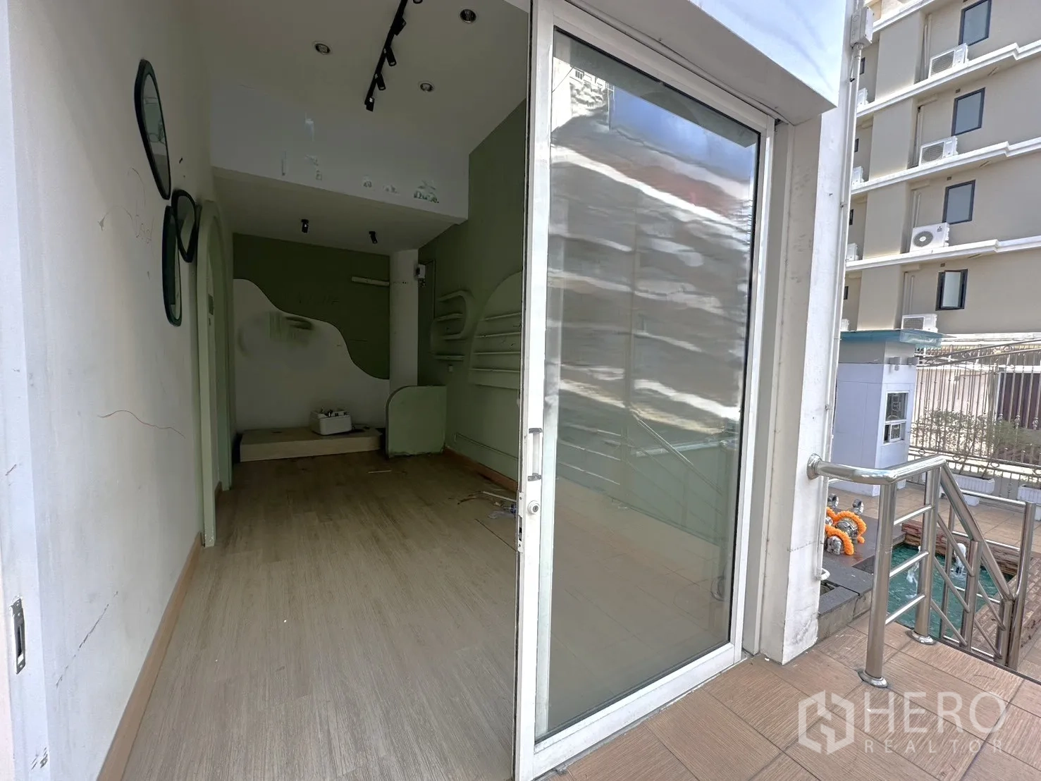 Retail Space for rent in Khlong Toei, Bangkok - Street-level entrance with sliding glass storefront, railing and steps leading into the compact shop.