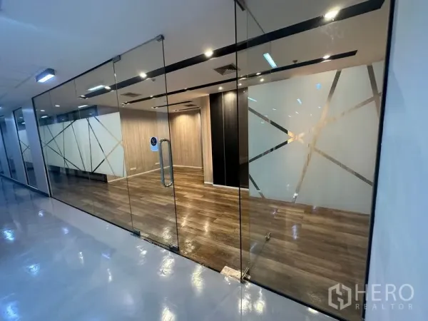 办公空间 出租 - 玻璃门面办公室入口，几何磨砂图案，内部木地板温馨可见。