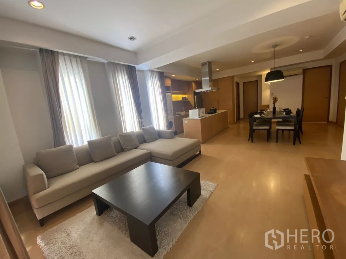 คอนโด ให้เช่าในWatthana, Bangkok - ห้องนั่งเล่นแบบเปิดโล่ง โซฟาเข้ามุม โต๊ะกลาง และหน้าต่างสูงพร้อมผ้าม่านในคอนโดกรุงเทพฯ