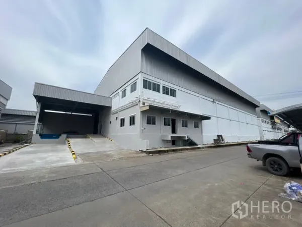 Warehouse for rent in Lat Krabang, Bangkok - Exterior of modern high-clearance warehouse with mezzanine office and covered loading dock with ramp in Lat Krabang, Bangkok.