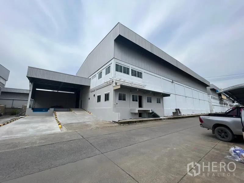Warehouse for rent in Lat Krabang, Bangkok - Exterior of modern high-clearance warehouse with mezzanine office and covered loading dock with ramp in Lat Krabang, Bangkok.