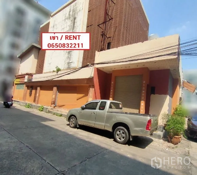 พื้นที่ขายปลีก ให้เช่าในWatthana, Bangkok - ด้านหน้าตึกเชิงพาณิชย์ พร้อมประตูม้วนและที่จอดรถริมถนน