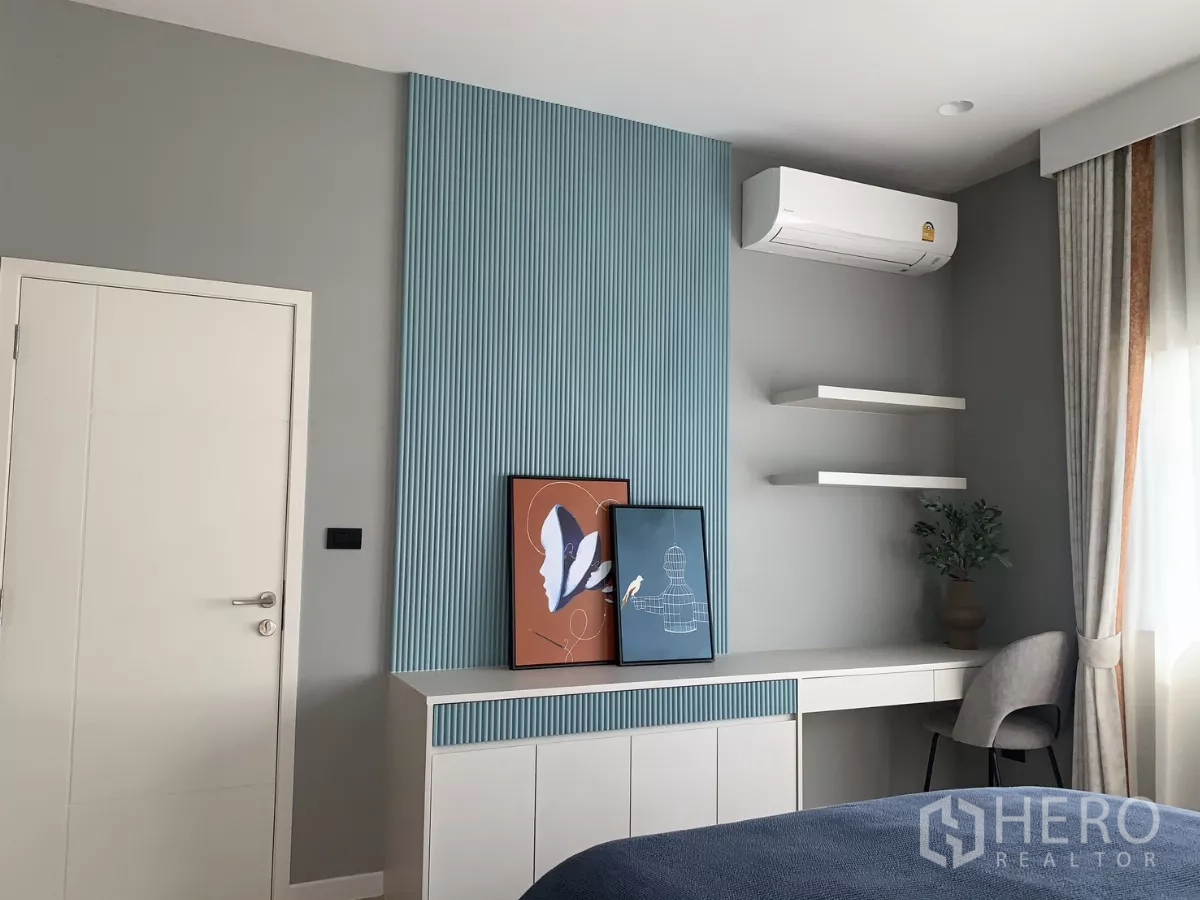 Detached House for rent in Bang Kapi, Bangkok - Bedroom corner with built‑in study desk, floating shelves and air conditioner.