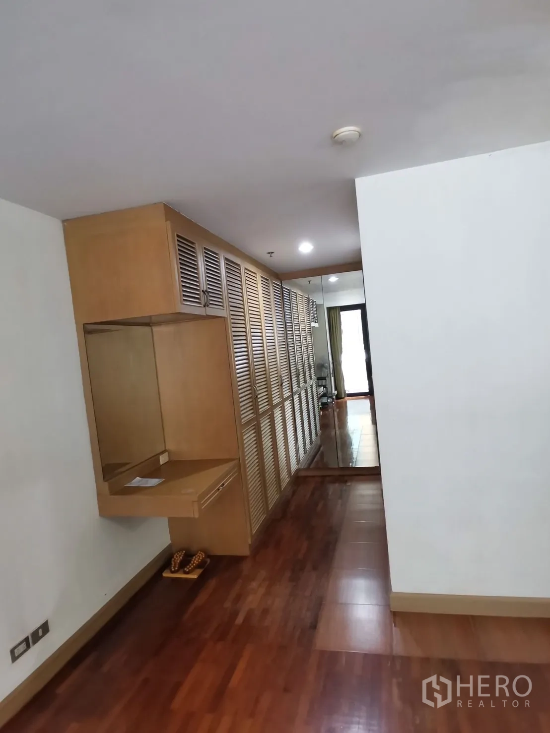 คอนโด ให้เช่าในPathum Wan, Bangkok - โถงทางเดินมีตู้บิวท์อินบานเกล็ดยาวตลอดแนว พร้อมโต๊ะเครื่องแป้งเหนือพื้นไม้