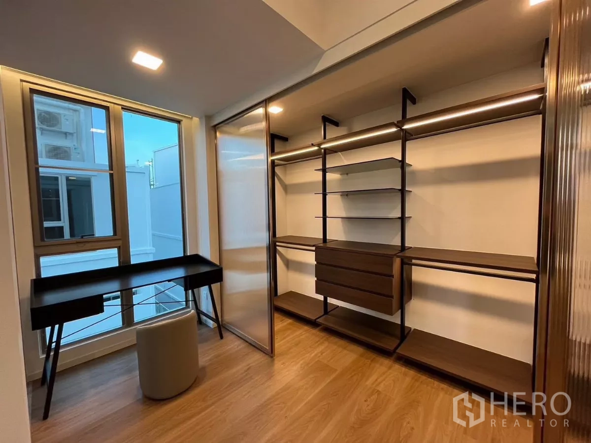 独立式住宅 出租在Saphan Sung, Bangkok - 步入式衣帽间与书写区，内置搁架、书桌与大窗。