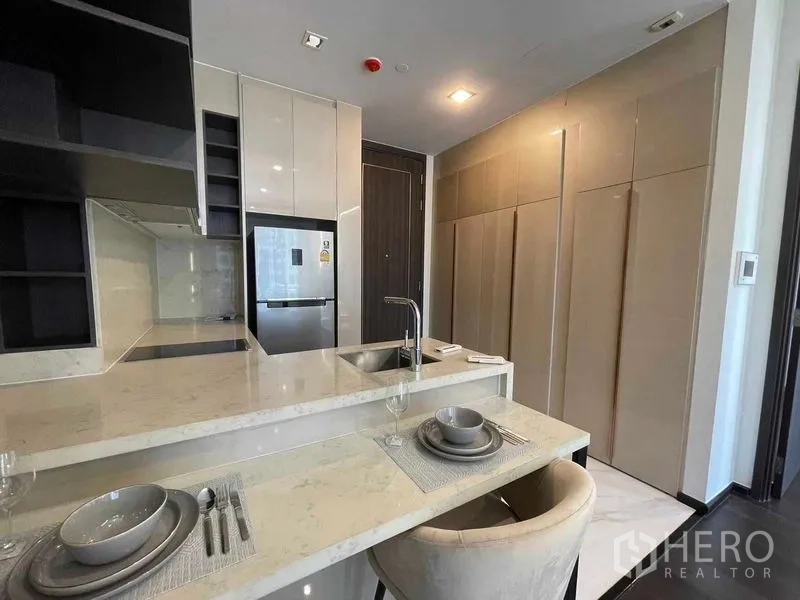 คอนโด ให้เช่า - ครัวขนาดกะทัดรัดพร้อมเคาน์เตอร์หินอ่อน ซิงก์ และตู้เย็นบิวท์อิน