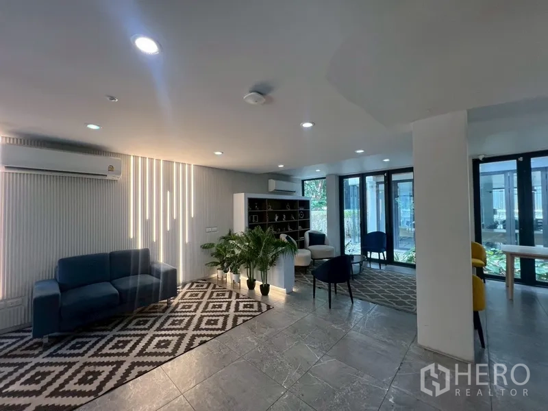 带办公室的家 出租或出售在Phra Khanong, Bangkok - 带沙发与书柜的接待区，大窗采光