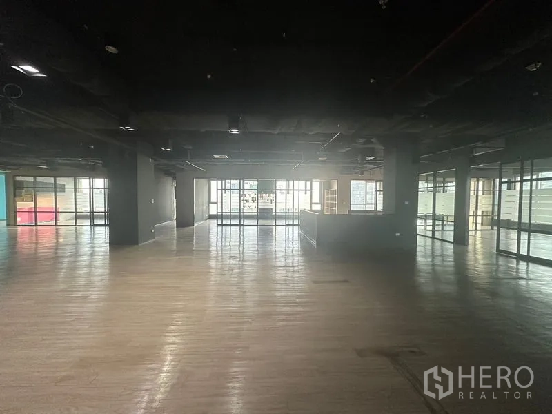 Office Space for rent in Bang Rak, Bangkok - Expansive office area with reception counter and glass-enclosed rooms along the side.