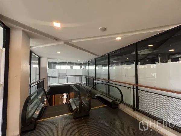 零售空间 出租在Watthana, Bangkok - 自动扶梯通向明亮的零售走廊，配落地窗