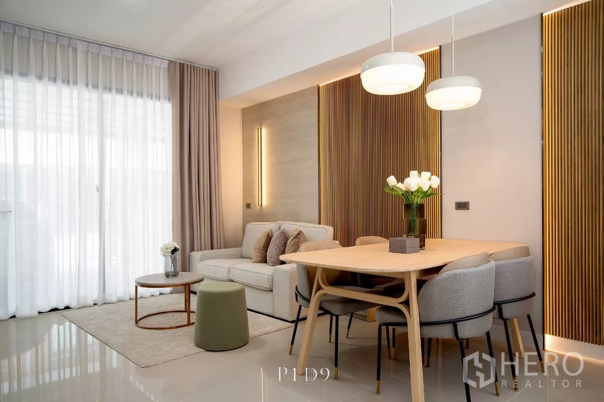 Townhouse for rent in Bang Phli, Samut Prakan - Bright living and dining area with wood accent wall, pendant lights and a six‑seat table