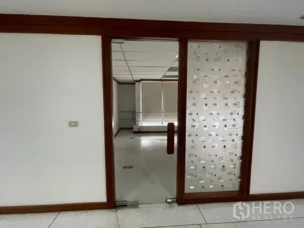 Office Space for rent in Khlong Toei, Bangkok - Wood-framed doorway with a frosted glass panel leading into the office suite.