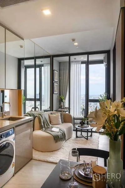 คอนโด ให้เช่าในChatuchak, Bangkok - มุมมองจากครัวและโต๊ะทานอาหารไปยังห้องนั่งเล่นและระเบียงกับวิวเมืองกว้าง