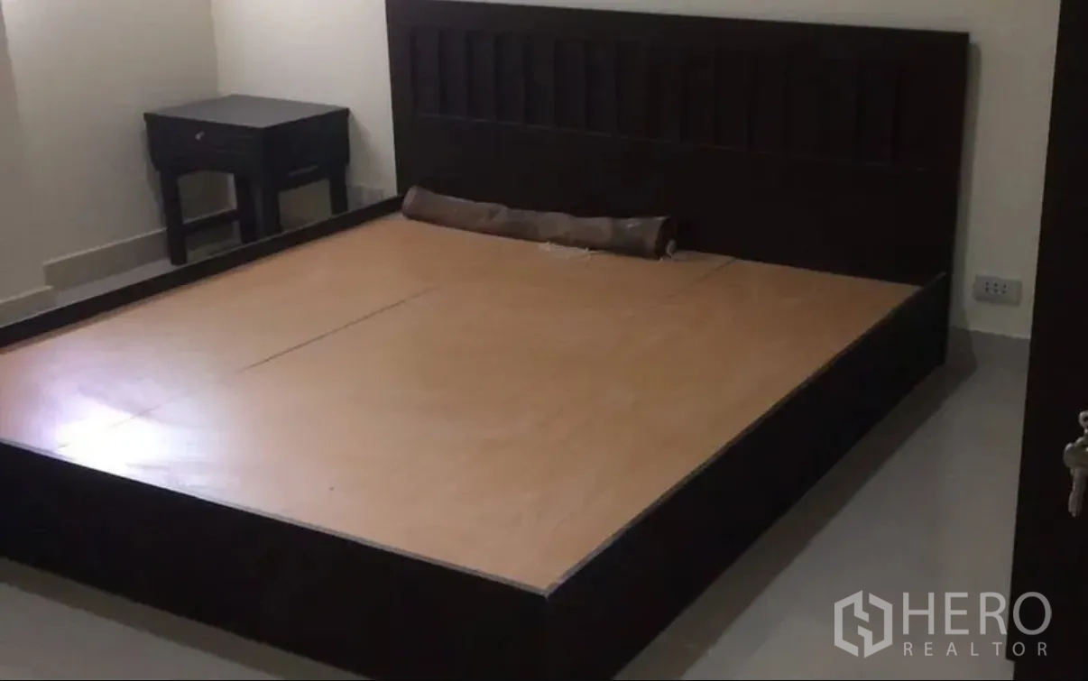 公寓 for sale in Watthana, Bangkok - 卧室配深色木质床架与床头柜。