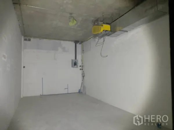 Retail Space for rent in Watthana, Bangkok - Raw 35 sqm retail interior with bare concrete floor, exposed ceiling duct and electrical panel in Watthana, Bangkok.