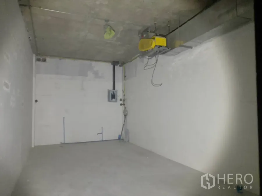 零售空间 出租在Watthana, Bangkok - 35㎡零售铺内部，水泥地面、裸顶管线与电箱，曼谷瓦塔那。